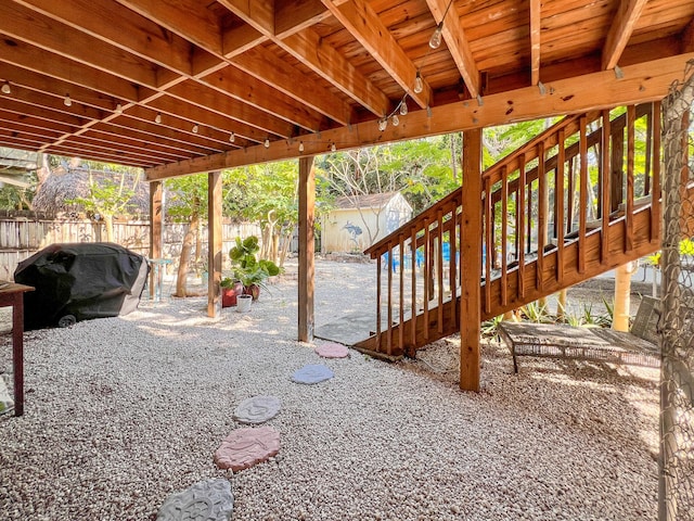 view of patio featuring a grill and a storage shed