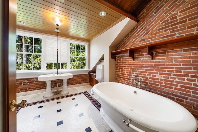 bathroom with ornamental molding, brick wall, wooden ceiling, and a tub to relax in