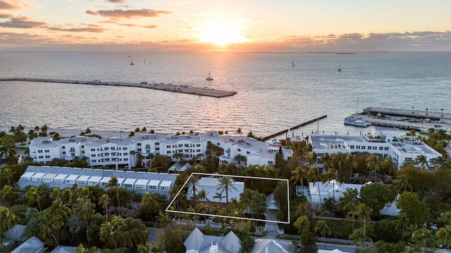 aerial view at dusk featuring a water view