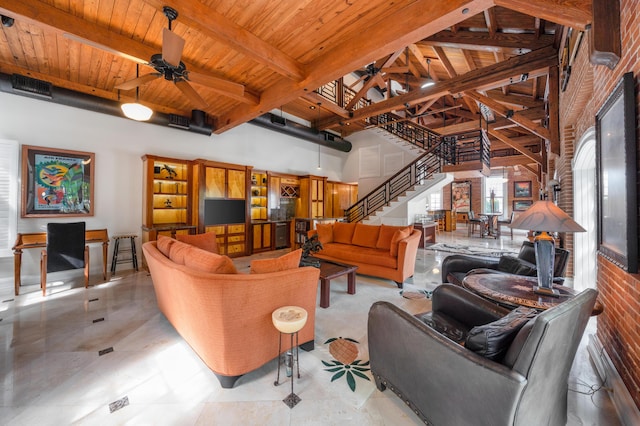 living room with beam ceiling, wooden ceiling, ceiling fan, and a high ceiling