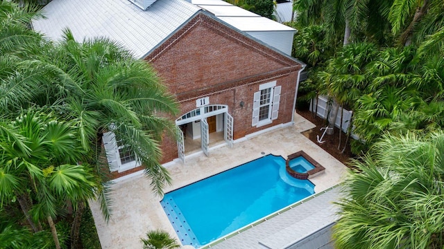 view of swimming pool featuring an in ground hot tub and a patio