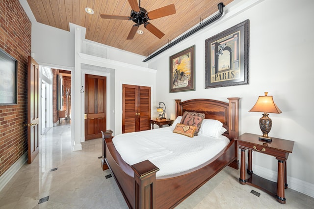 bedroom with wood ceiling, ceiling fan, brick wall, and a closet