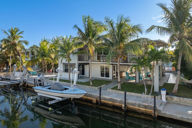188 Indian Mound Trl, Islamorada, FL 33036 - dock featuring boat lift, a patio area, a balcony, a water view, and a yard