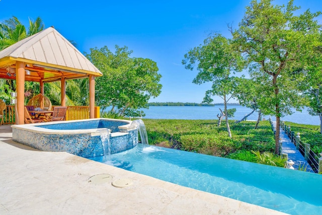 view of pool with a water view, a patio area, a pool with connected hot tub, and a gazebo