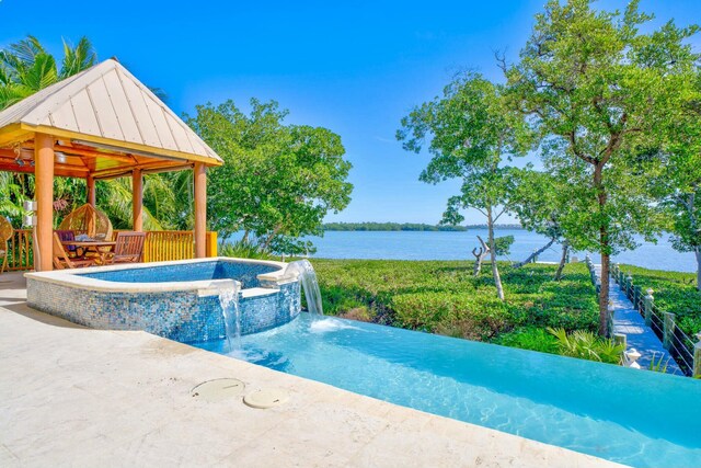 view of swimming pool with a water view, a pool with connected hot tub, a patio, and a gazebo