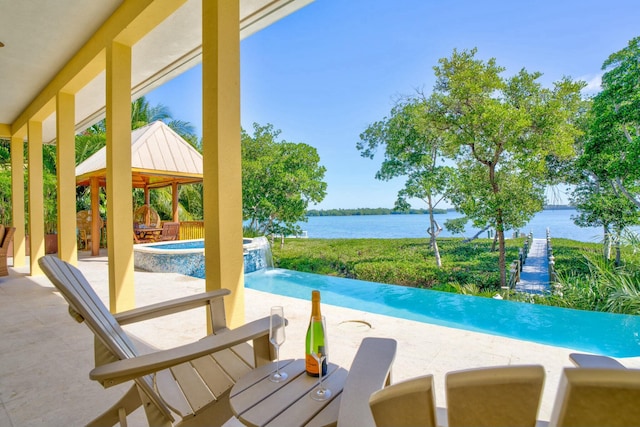 view of swimming pool featuring a water view, a gazebo, a pool with connected hot tub, and a patio