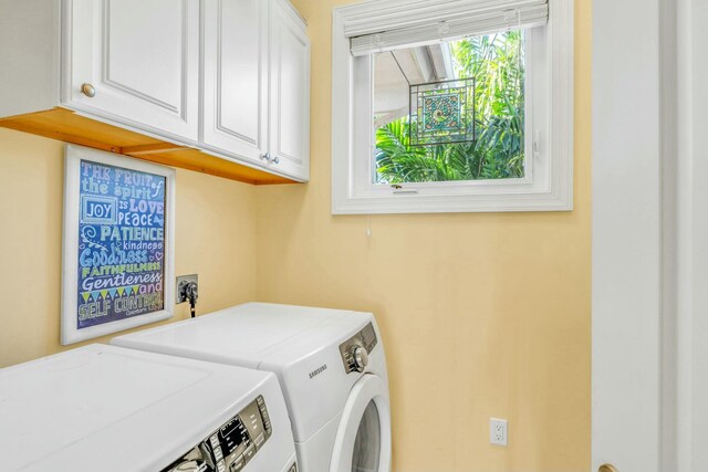 clothes washing area with cabinet space and washing machine and dryer