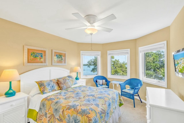 bedroom with light carpet, a ceiling fan, and baseboards