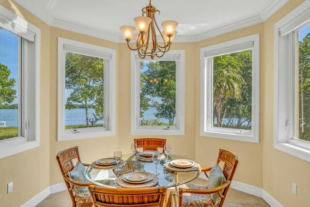 dining space with light tile patterned floors, ornamental molding, and baseboards