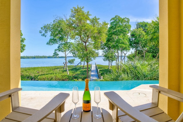 view of swimming pool with a water view and a patio area