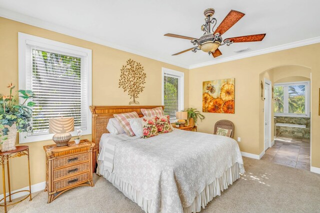 bedroom featuring arched walkways, light carpet, visible vents, baseboards, and ornamental molding