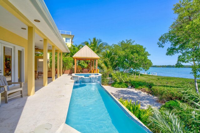 view of swimming pool with a gazebo, a patio, a water view, and a pool with connected hot tub