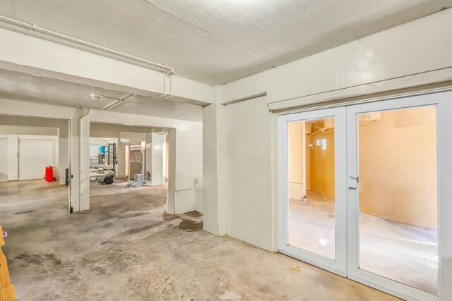 interior space with french doors and unfinished concrete floors