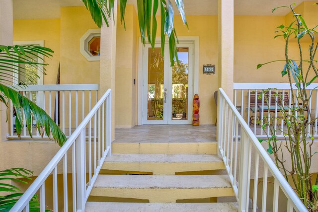 property entrance with stucco siding and french doors