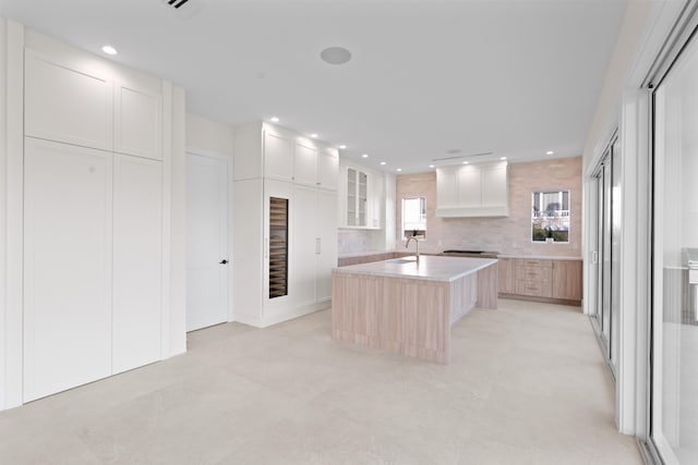194 Buttonwood Ln, Islamorada, FL 33036 - kitchen featuring a kitchen island with sink, recessed lighting, light countertops, backsplash, and premium range hood
