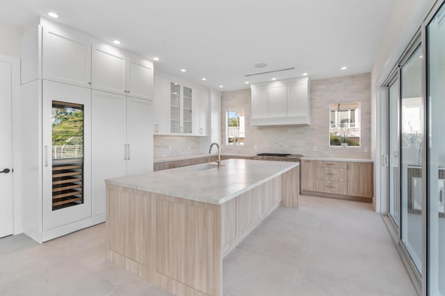 194 Buttonwood Ln, Islamorada, FL 33036 - kitchen with decorative backsplash, glass insert cabinets, an island with sink, recessed lighting, and white cabinetry