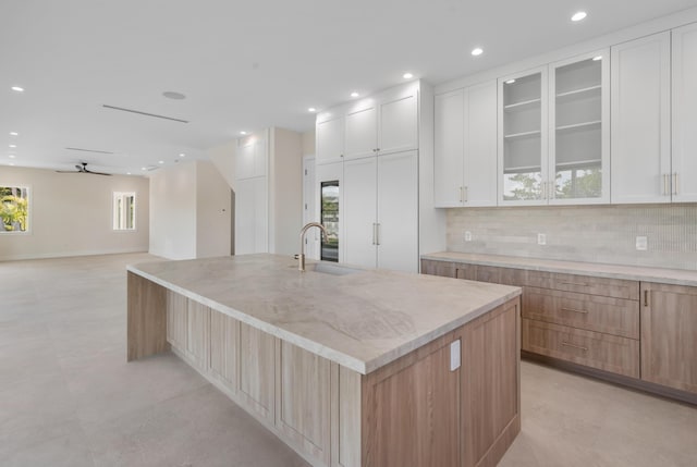 194 Buttonwood Ln, Islamorada, FL 33036 - kitchen featuring decorative backsplash, a spacious island, light stone counters, recessed lighting, and glass insert cabinets