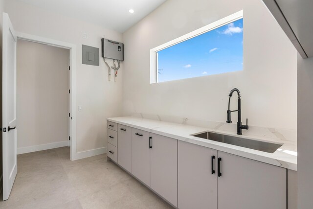 194 Buttonwood Ln, Islamorada, FL 33036 - kitchen with light stone counters, recessed lighting, concrete floors, white cabinetry, and electric panel