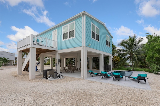 rear view of house with cooling unit, an outdoor living space, a patio, and a wooden deck