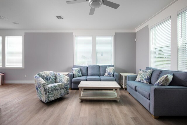 living room featuring crown molding, ceiling fan, and light hardwood / wood-style flooring