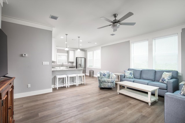 living room with ceiling fan and light hardwood / wood-style flooring