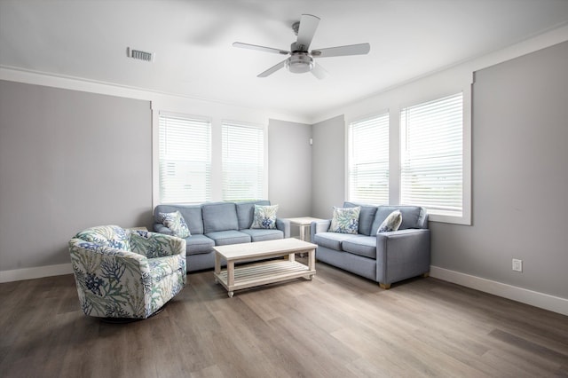 living room with hardwood / wood-style flooring, ornamental molding, and ceiling fan