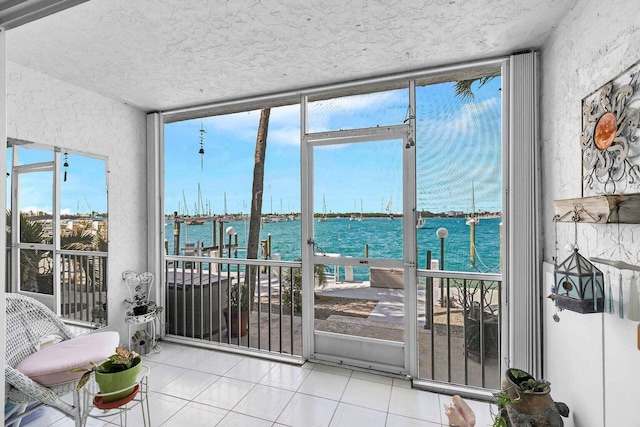 doorway to outside featuring a water view, expansive windows, and light tile patterned flooring