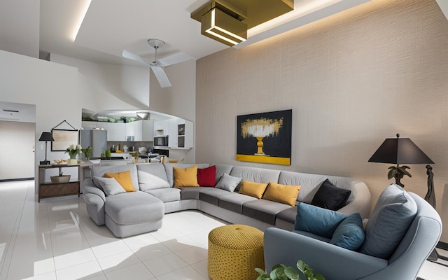 living room featuring light tile patterned floors, a towering ceiling, and ceiling fan