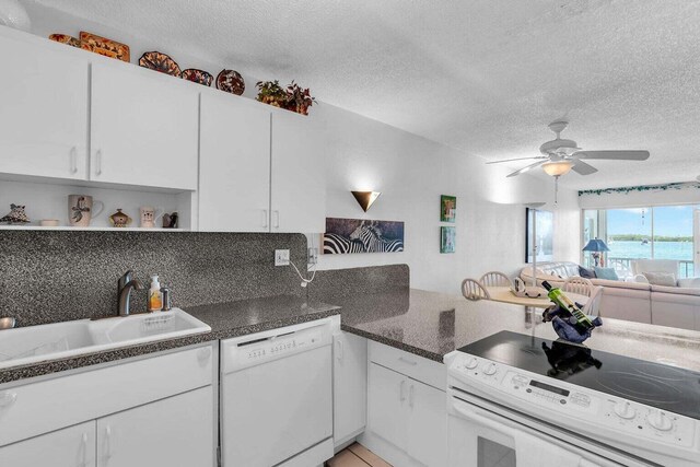 kitchen featuring sink, white appliances, ceiling fan, white cabinetry, and a textured ceiling