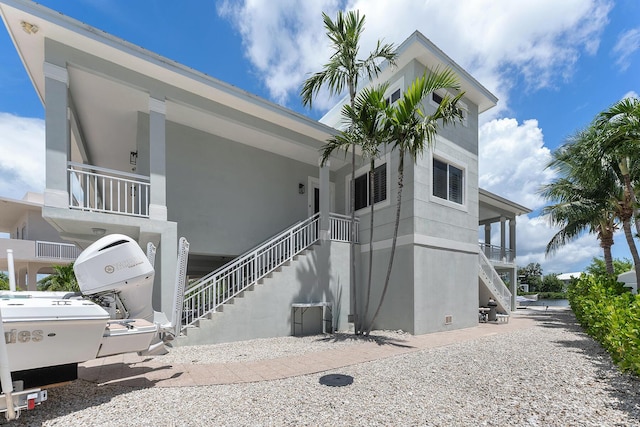 exterior space with stairway and stucco siding