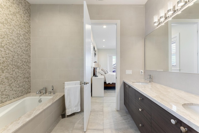 full bathroom with a sink, ensuite bath, tile patterned flooring, double vanity, and a bath