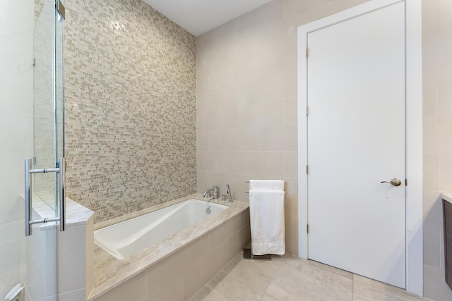 full bath featuring tile walls, a garden tub, tile patterned floors, and a shower stall