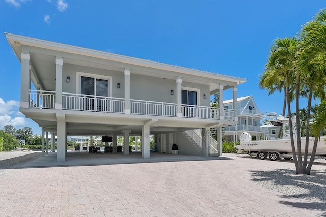 view of building exterior featuring stairs, a carport, and decorative driveway