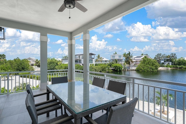 balcony with outdoor dining area, a water view, a residential view, and ceiling fan