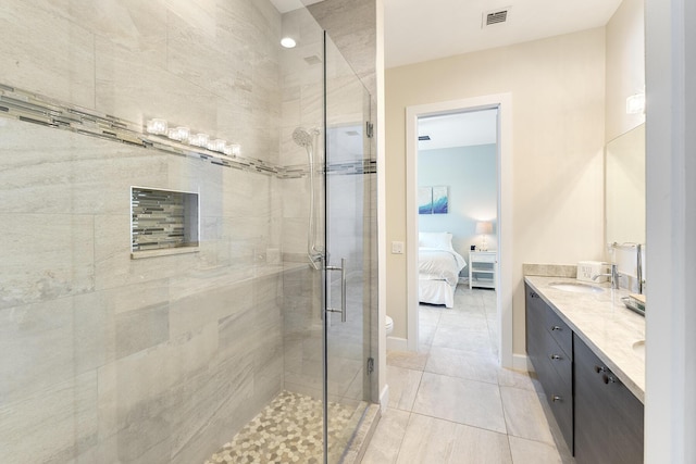 ensuite bathroom featuring visible vents, a shower stall, baseboards, double vanity, and ensuite bath