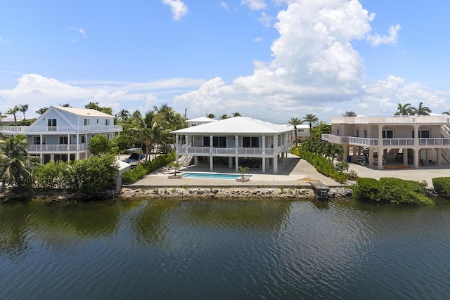 back of house featuring an outdoor pool and a water view