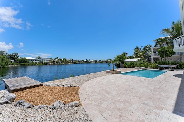 outdoor pool with a patio, a dock, and a water view