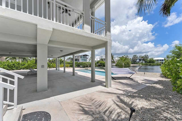 outdoor pool featuring a patio and a water view