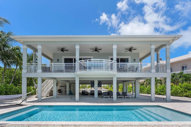 rear view of house with stairway, outdoor lounge area, an outdoor pool, a ceiling fan, and a patio