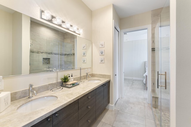 bathroom with double vanity, baseboards, a stall shower, and a sink