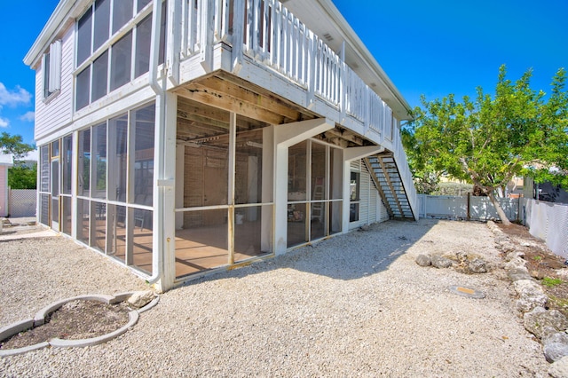 exterior space with a sunroom, a fenced backyard, a deck, and stairs