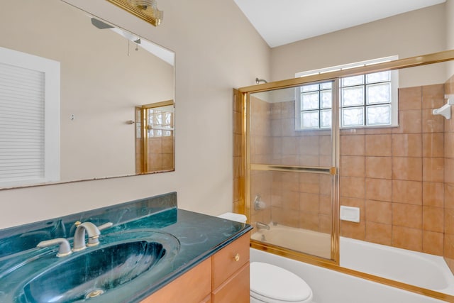 full bathroom featuring ceiling fan, vanity, toilet, and bath / shower combo with glass door