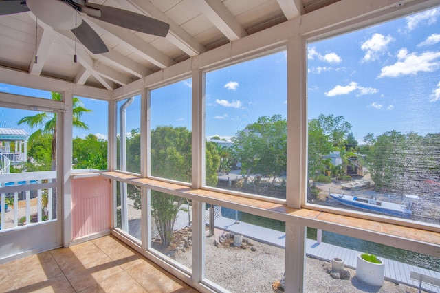 sunroom / solarium featuring lofted ceiling with beams and a ceiling fan