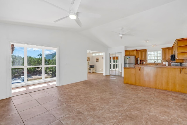 kitchen with ceiling fan, freestanding refrigerator, a peninsula, open shelves, and a sink