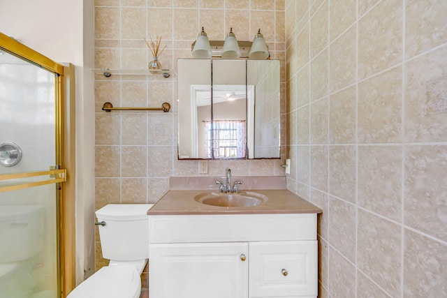 full bathroom featuring toilet, a stall shower, tile walls, and vanity