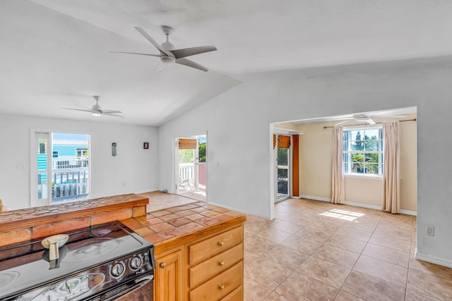 kitchen with a wealth of natural light, electric range, and tile countertops