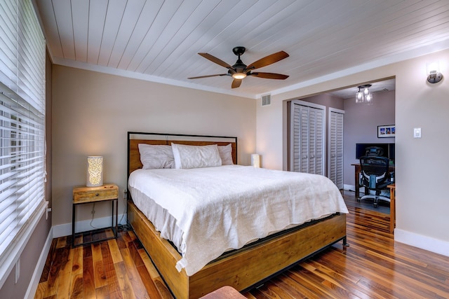 bedroom with ceiling fan, crown molding, wood ceiling, and dark hardwood / wood-style flooring