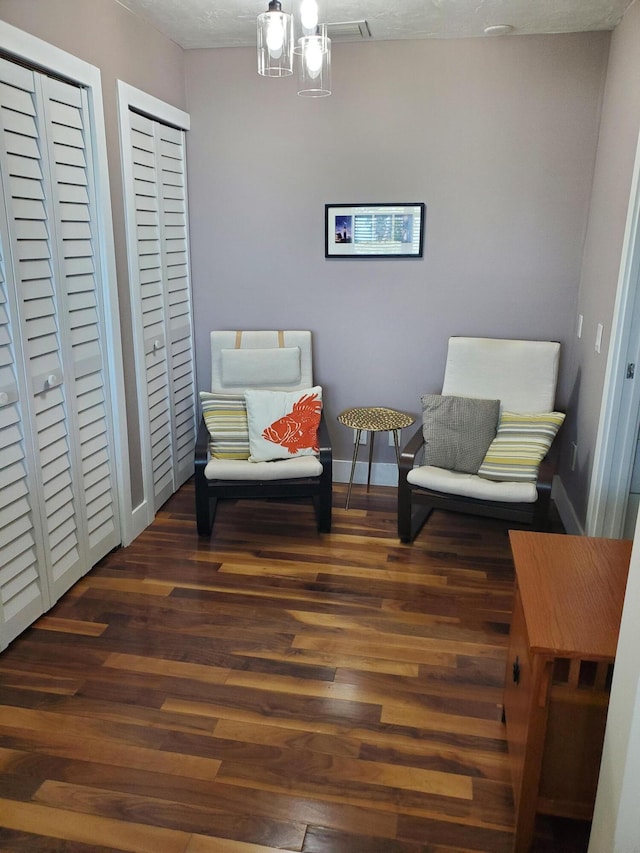 sitting room featuring dark wood-type flooring and a textured ceiling