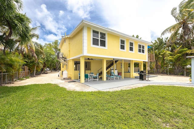 back of property with a patio, ceiling fan, and a lawn