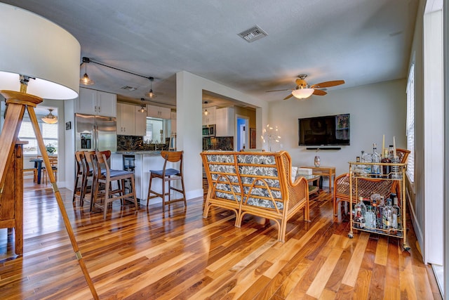 living room featuring ceiling fan and light hardwood / wood-style floors